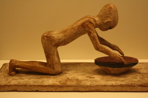 Estatua de madera egipcia de una mujer moliendo cereales